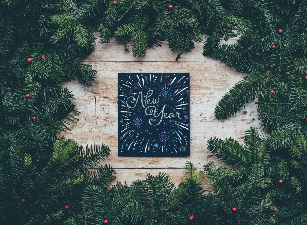 pine surrounding a happy new year chalk board