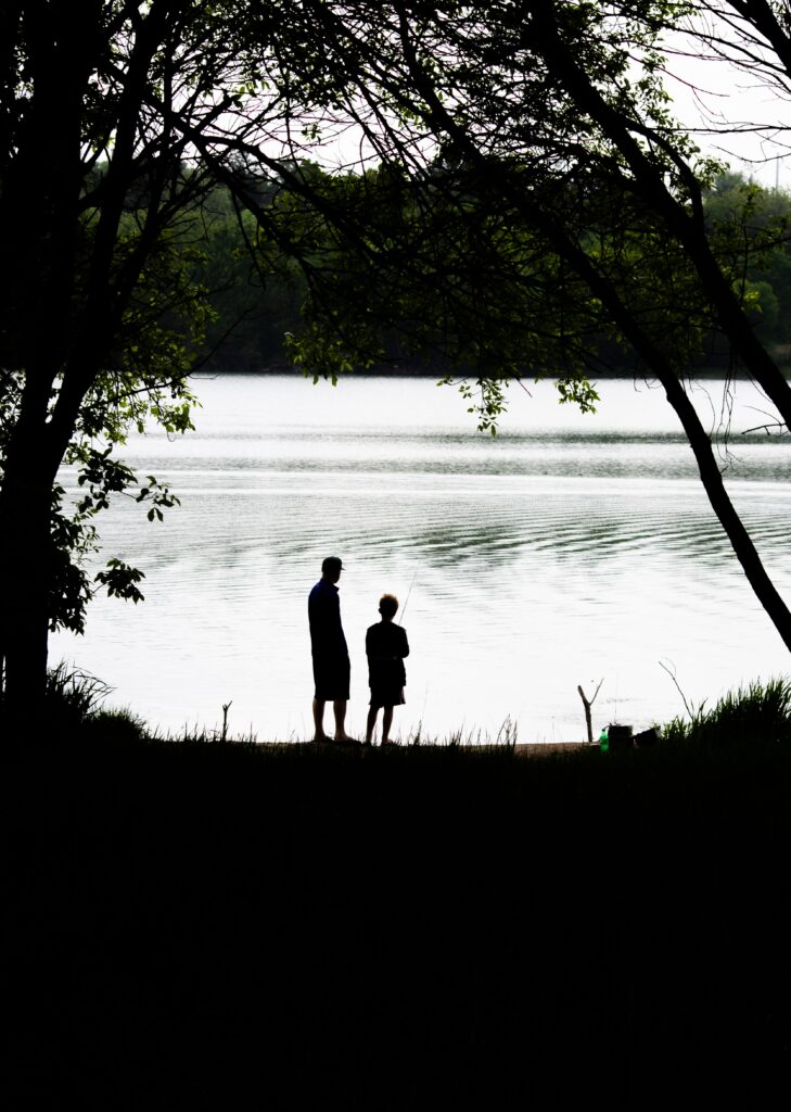 black and white photo of a dad and son fishing